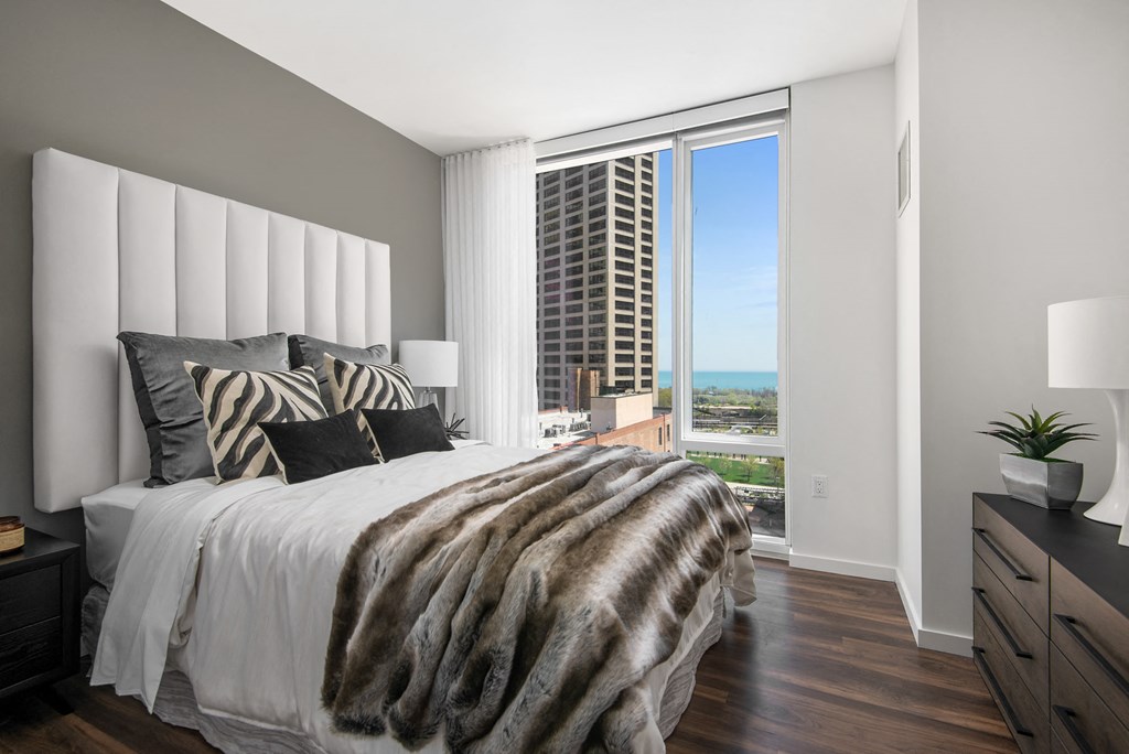 Furnished bedroom with floor to ceiling windows at Eleven40, Chicago