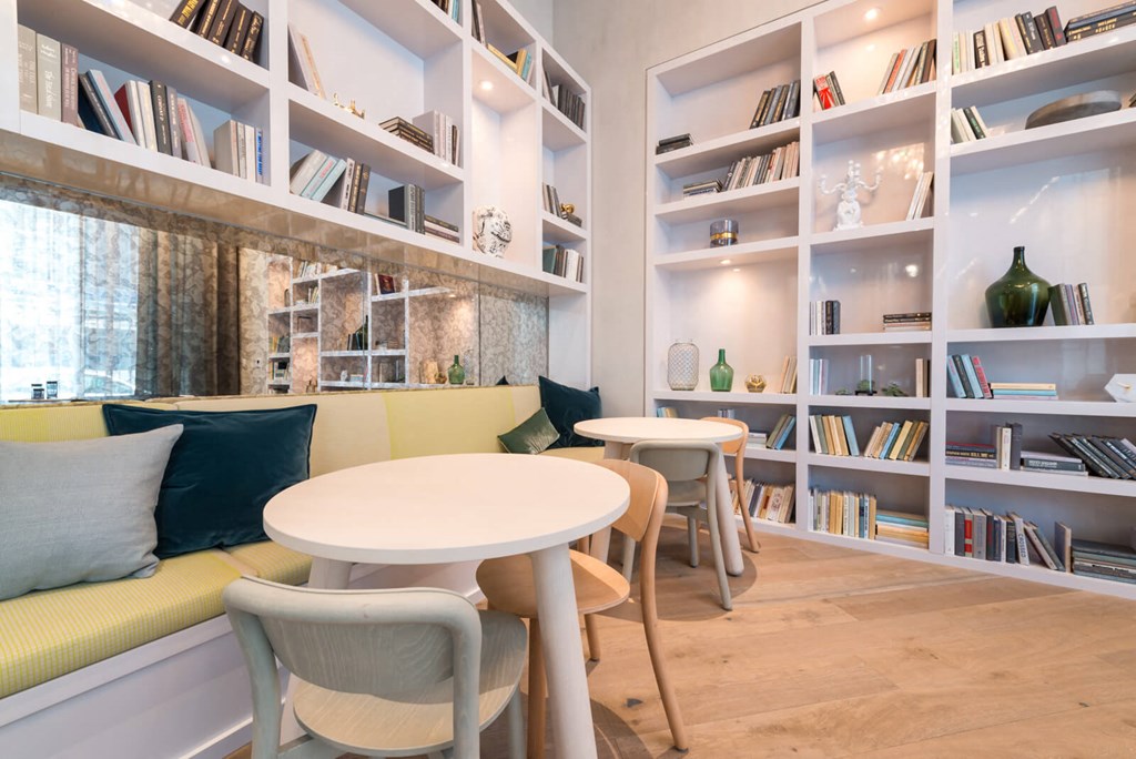 a seating area with a table and a book shelf