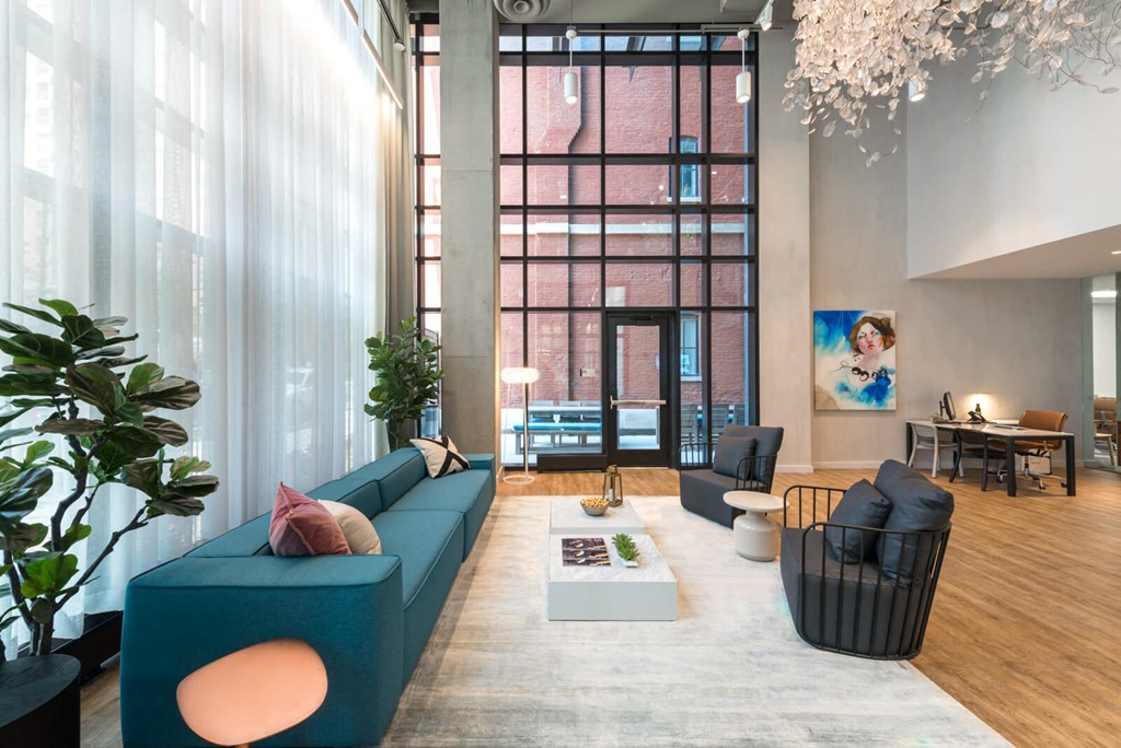 a living room with a blue couch and a large window