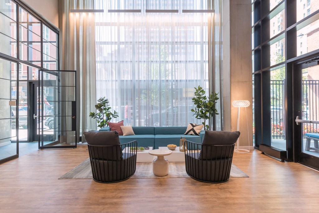 a living room with a couch and chairs and a large window
