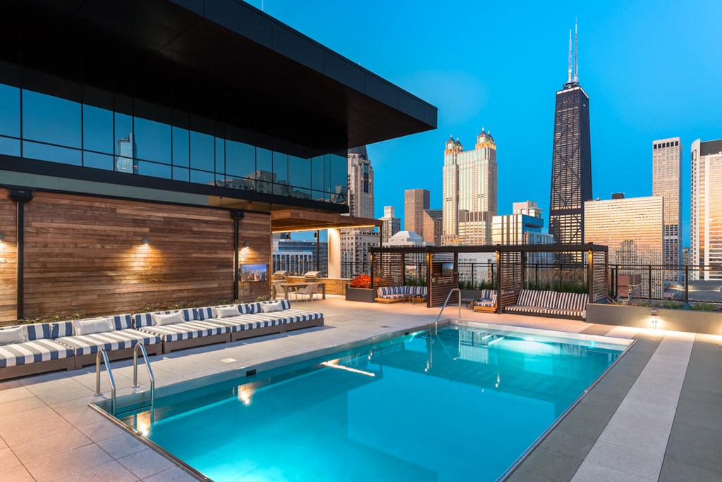 the pool on the rooftop of a building with the city skyline in the background
