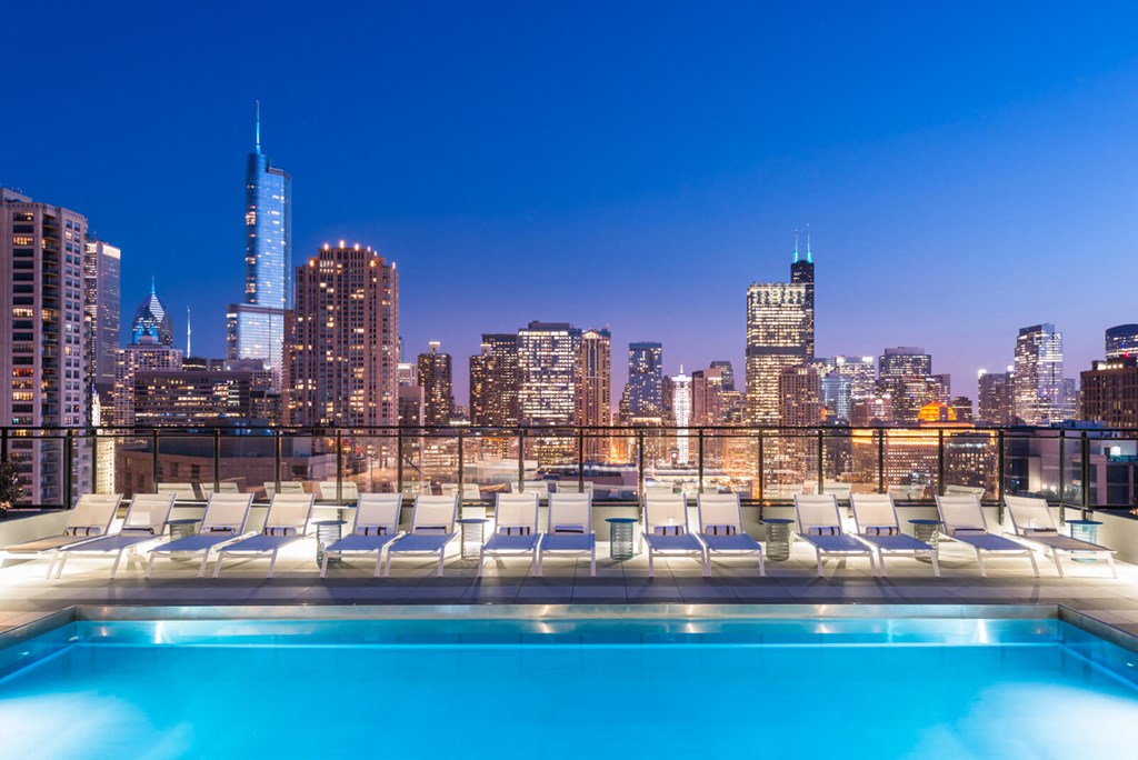 a pool on the roof of a building with a city skyline