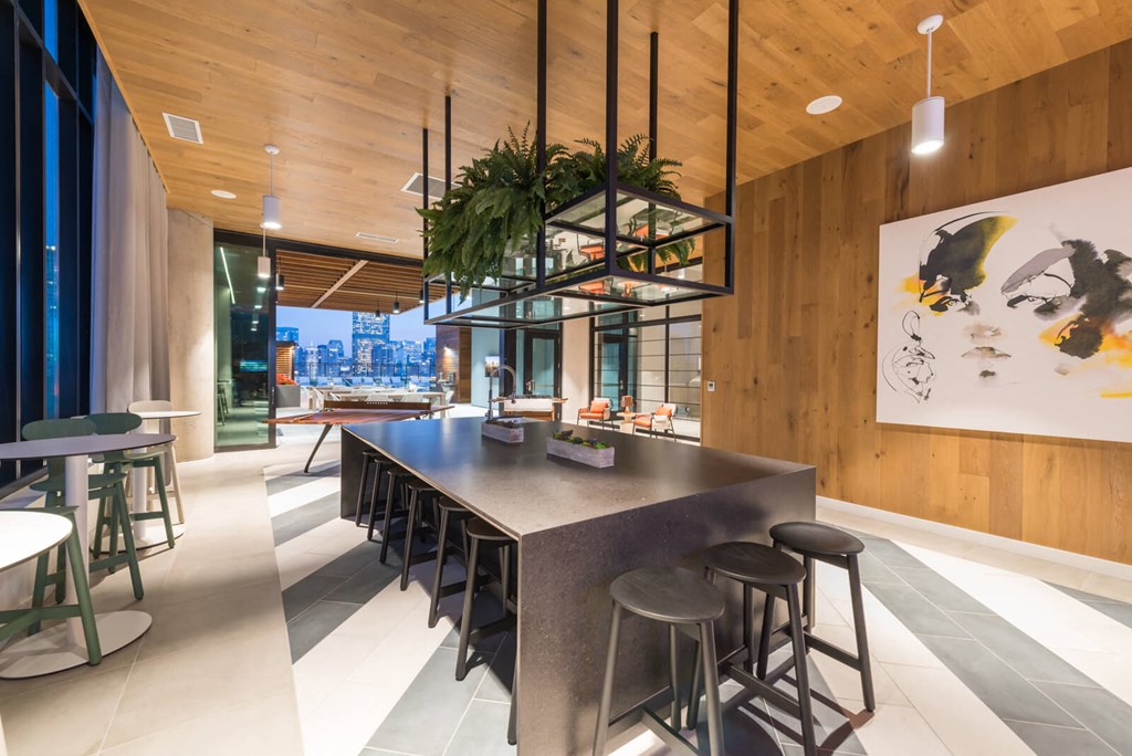 a large dining room with a long table and stools