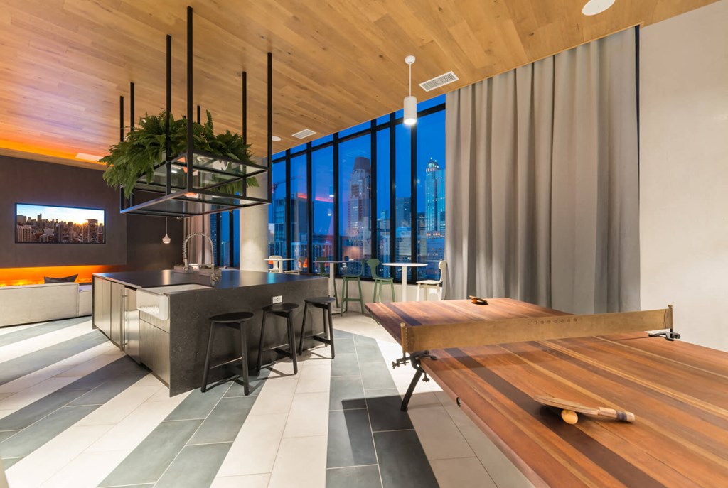 a dining room with a table and a bar in a room with large windows