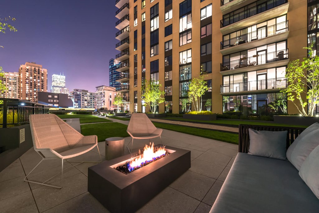 a patio with a fire pit at night