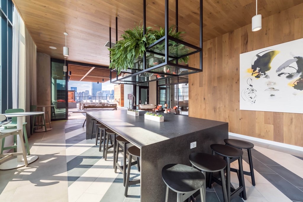 a large kitchen with a long island with stools and a long table with chairs