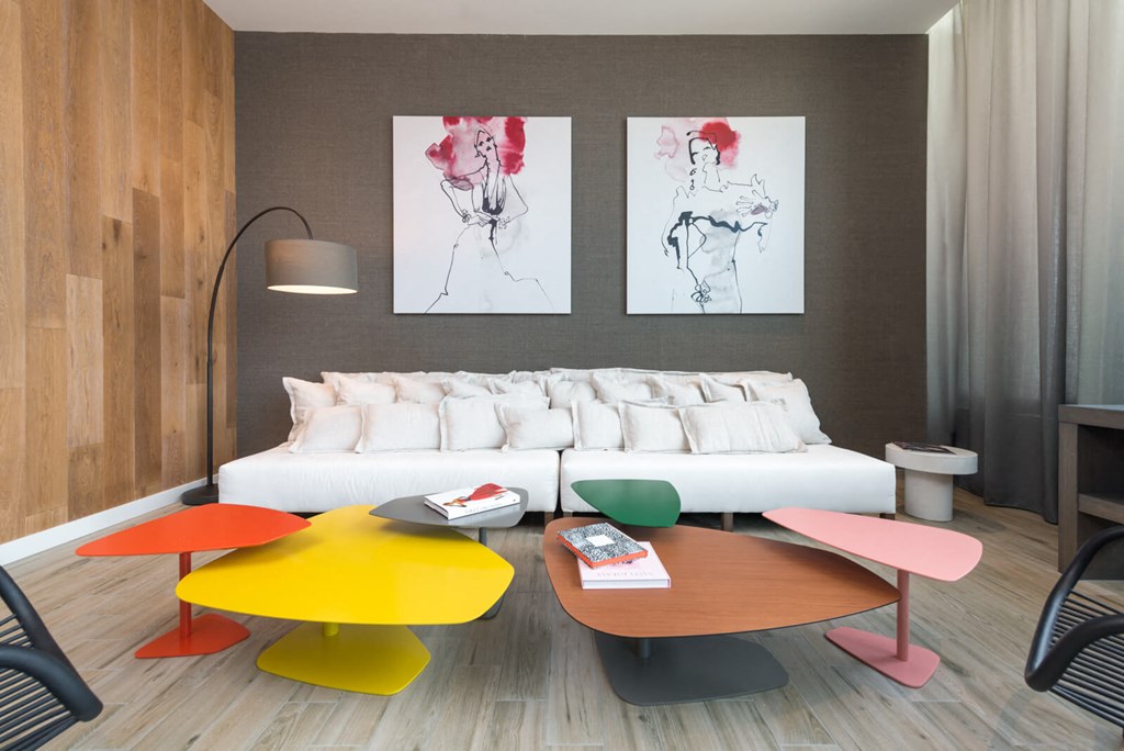 a living room with a white couch and colorful tables