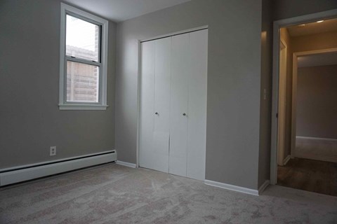 a bedroom with a closet and a window
