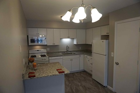 full kitchen with granite counter tops and white cabinets