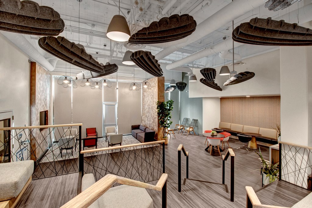a living room with wooden floors and chairs and a table with chairs