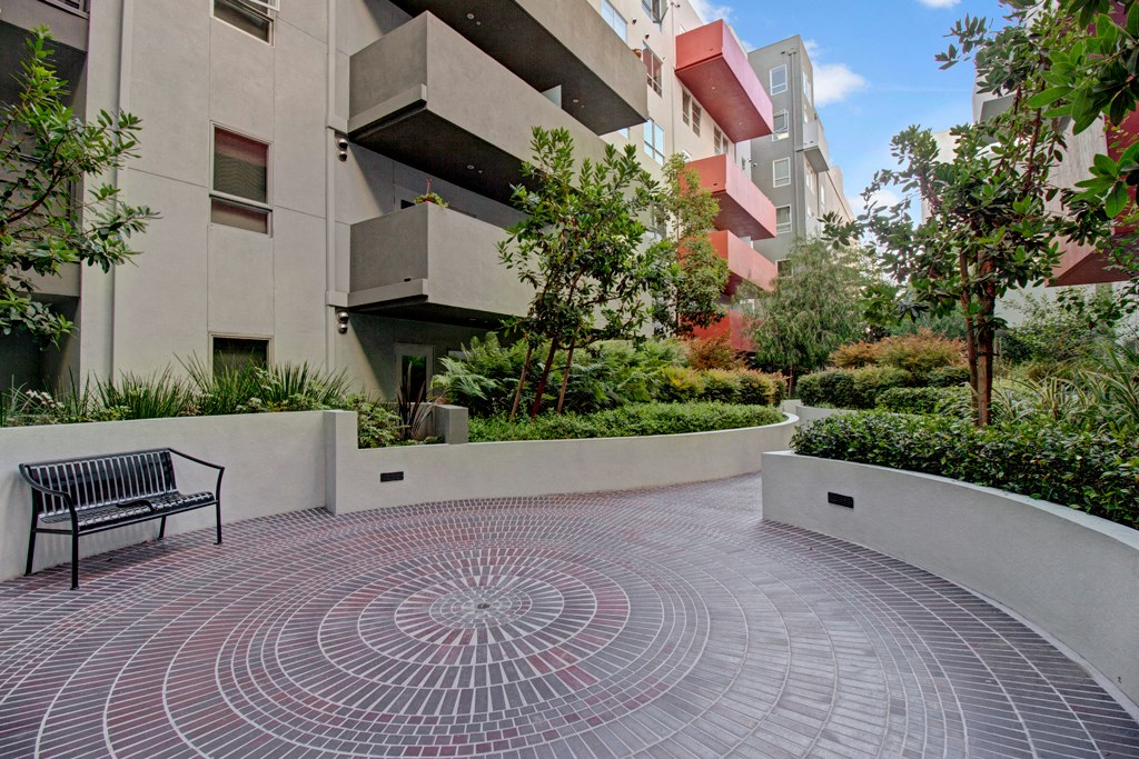 a park bench sitting in front of an apartment building