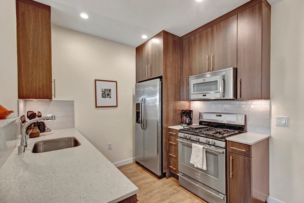 a kitchen with stainless steel appliances and white counter tops