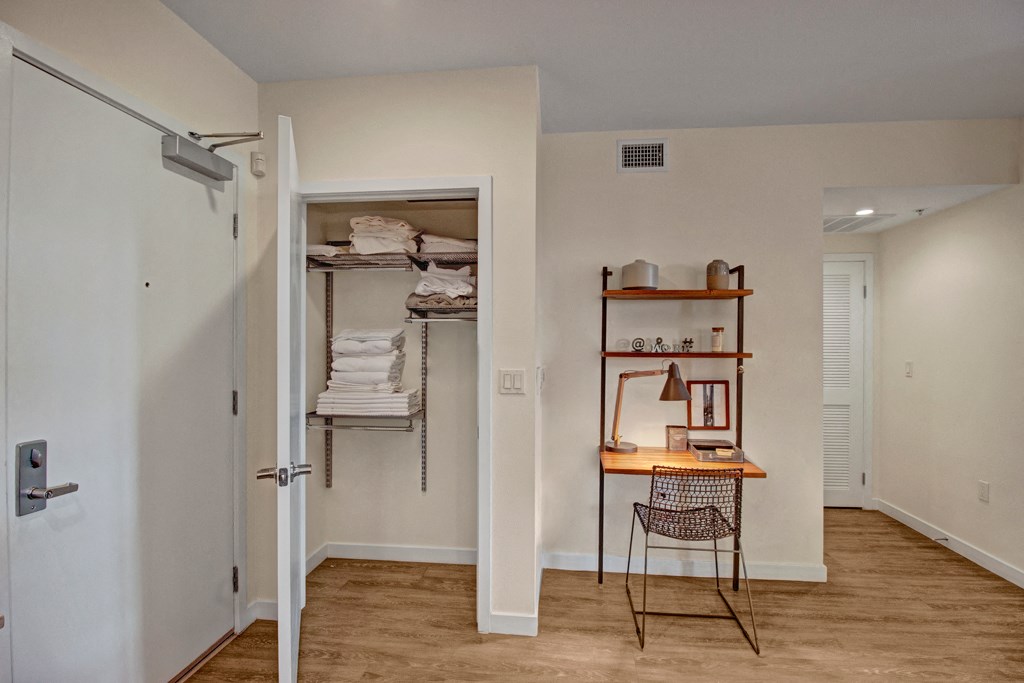 a room with an open door and a closet with shelves