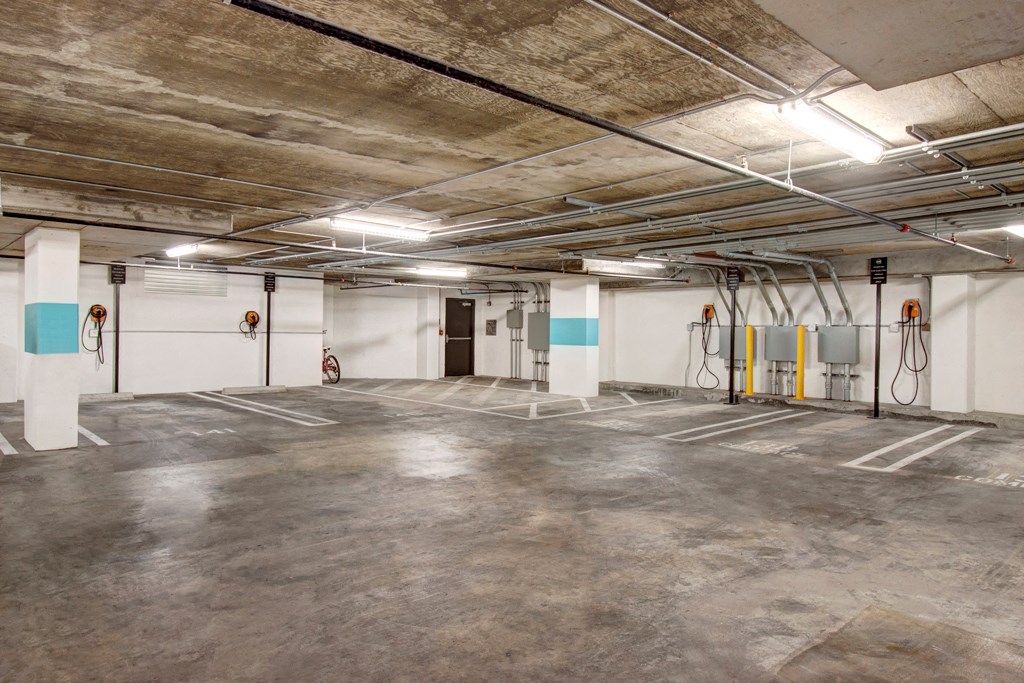 an empty parking garage with white walls and concrete floors