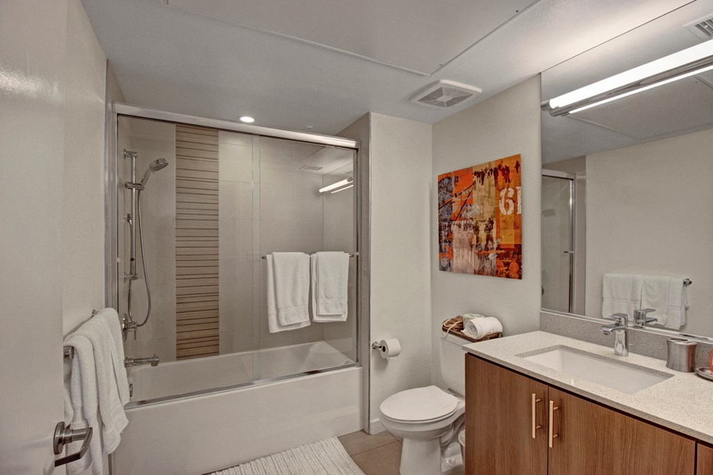 a bathroom with a shower and a sink and a toilet