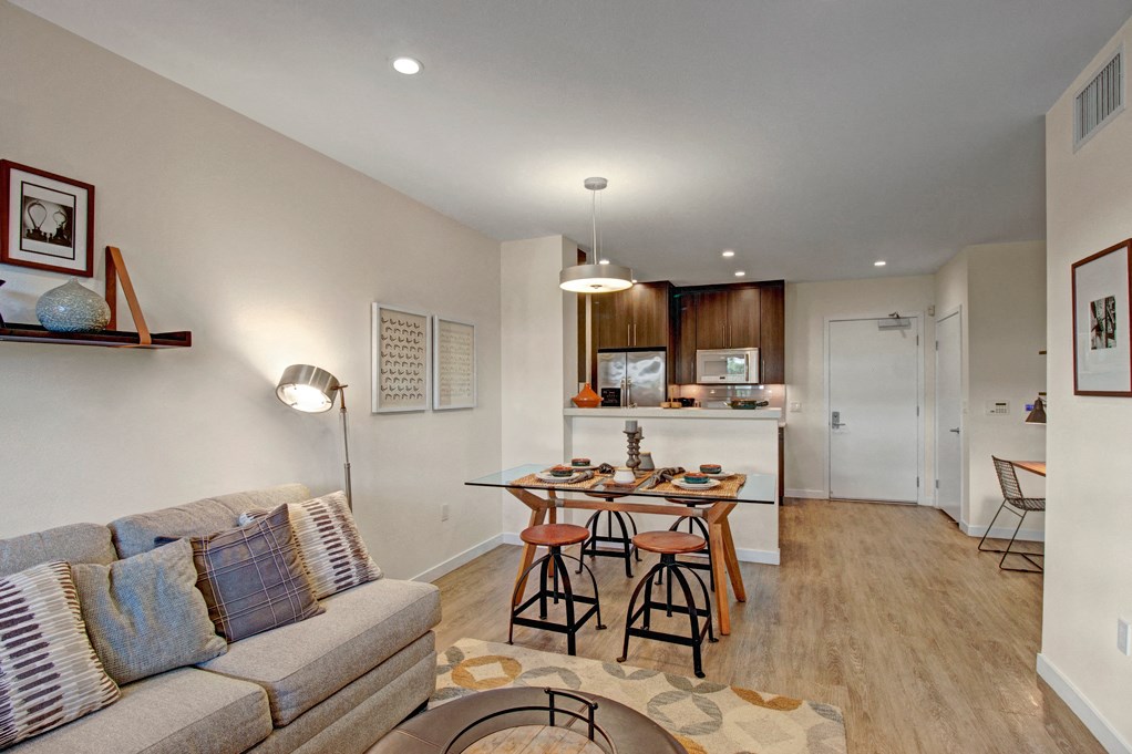 a living room and kitchen with a couch and a table