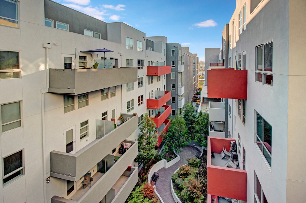 an aerial view of a group of buildings with red balconies