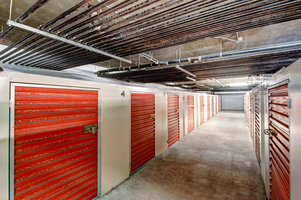 a hallway of garage doors in a building with concrete floors and metal ceilings