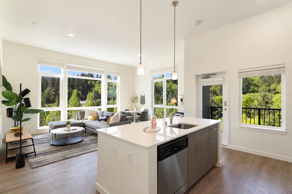 a kitchen and living room with large windows and a sink