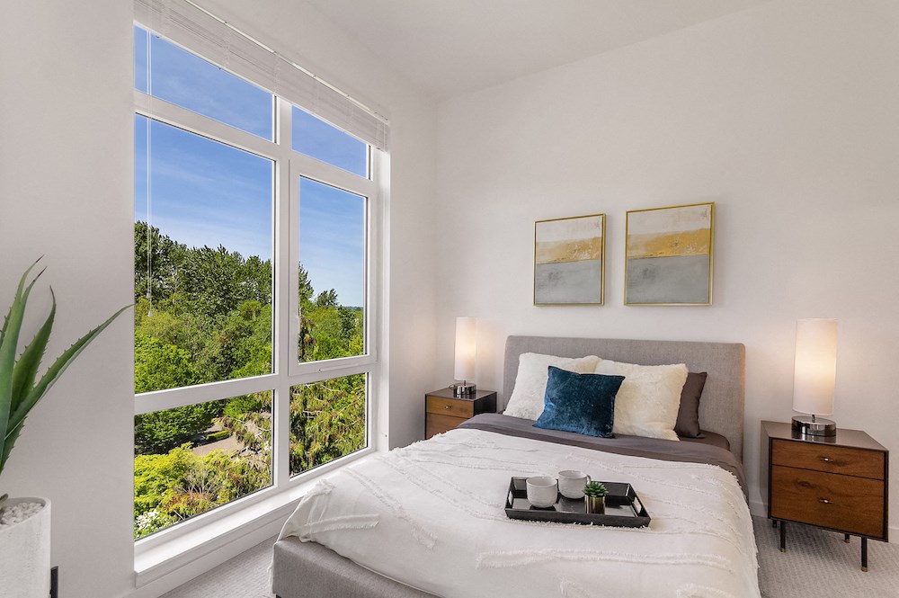 a bedroom with a large window and a bed
