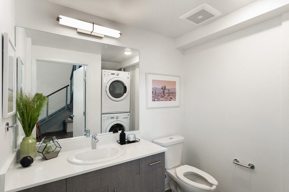 a bathroom with a toilet sink and a washing machine
