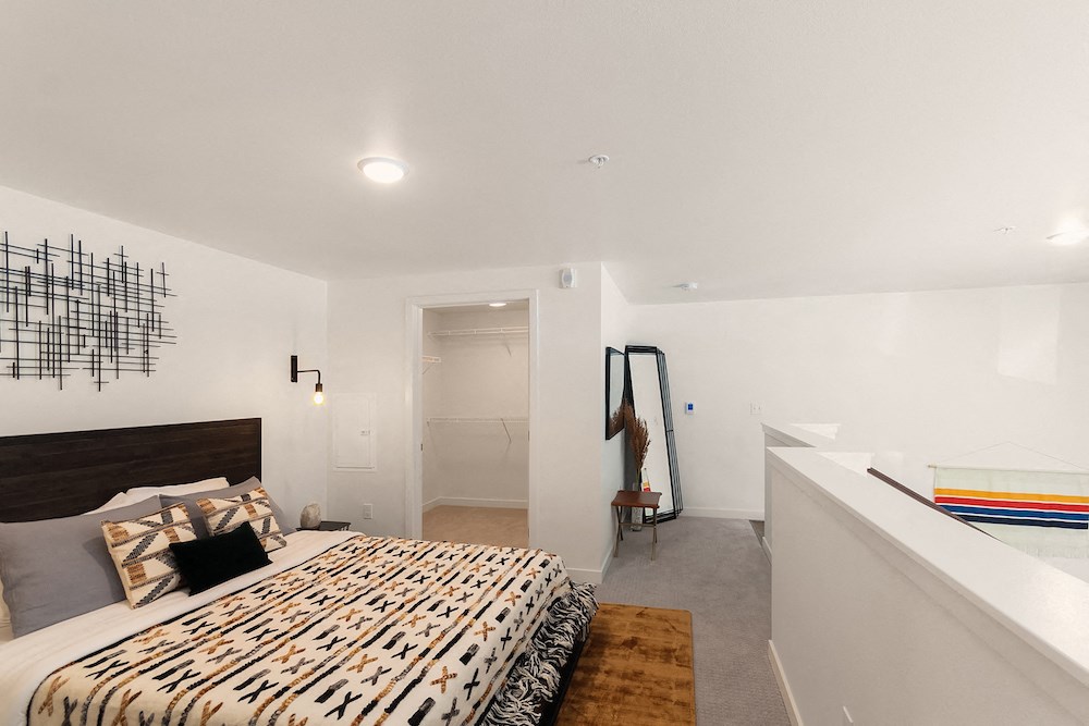 the master bedroom has a large bed and a large window