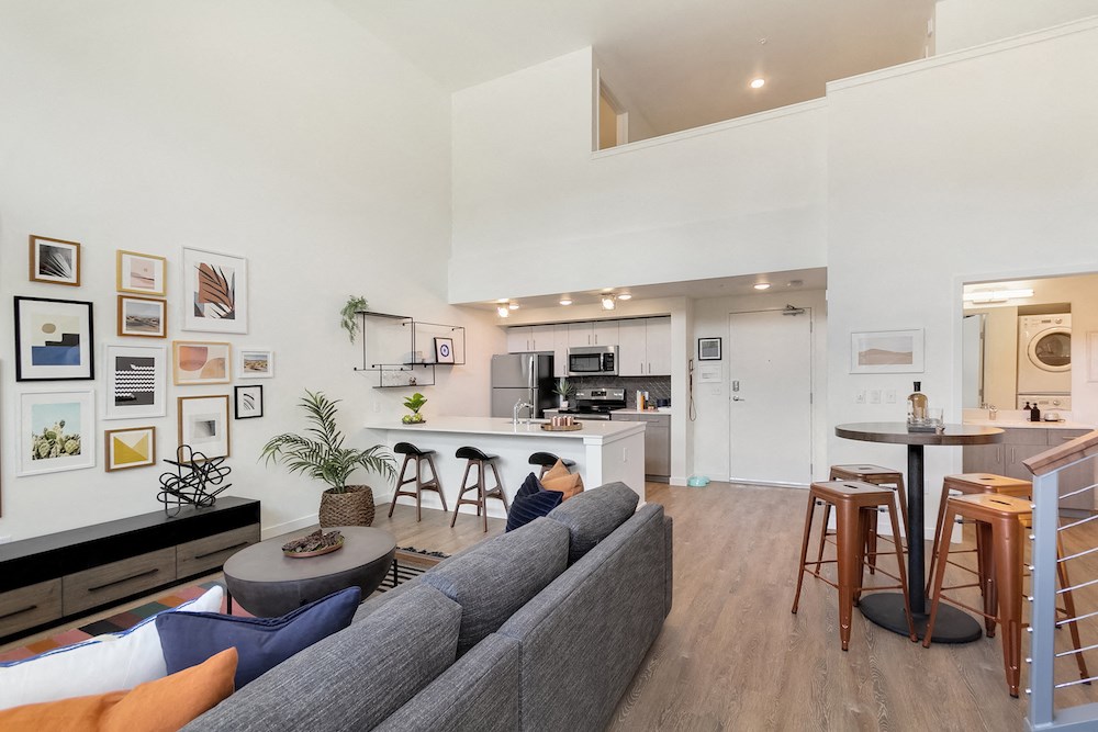 a living room and kitchen with a couch and a table
