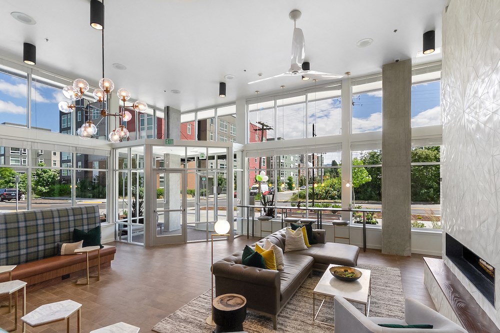 a living room with couches and a large amount of windows
