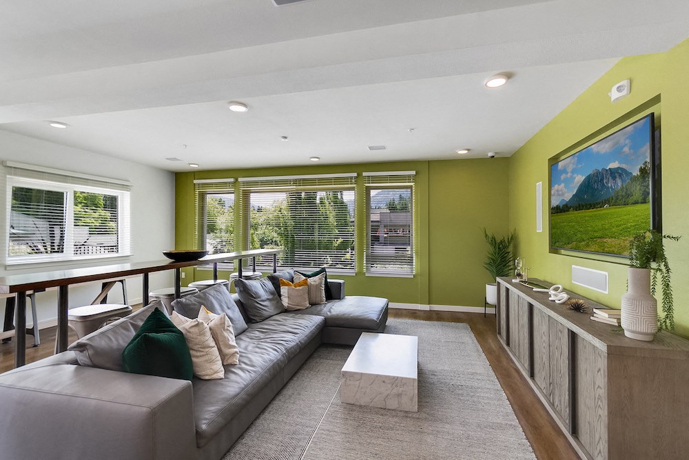 a living room with green walls and a gray couch