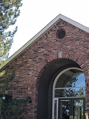 Westlake Greens Leasing Office brick front entrance with green plants and flowers