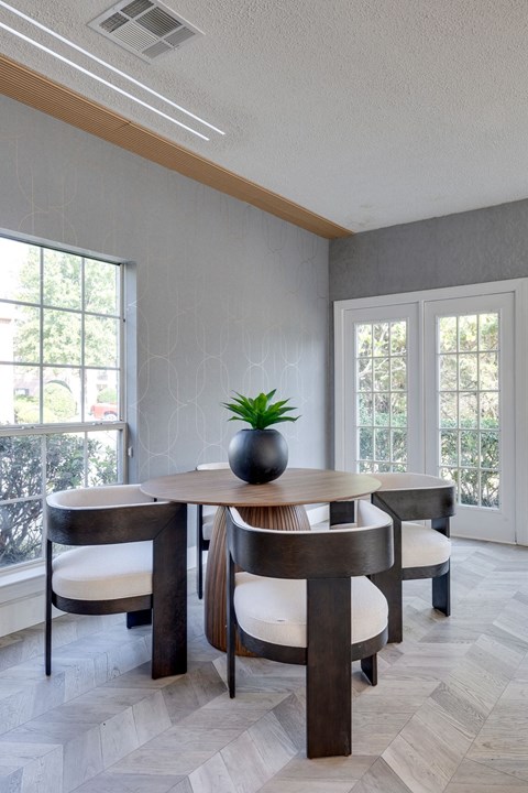 A dining room with a round table and chairs.