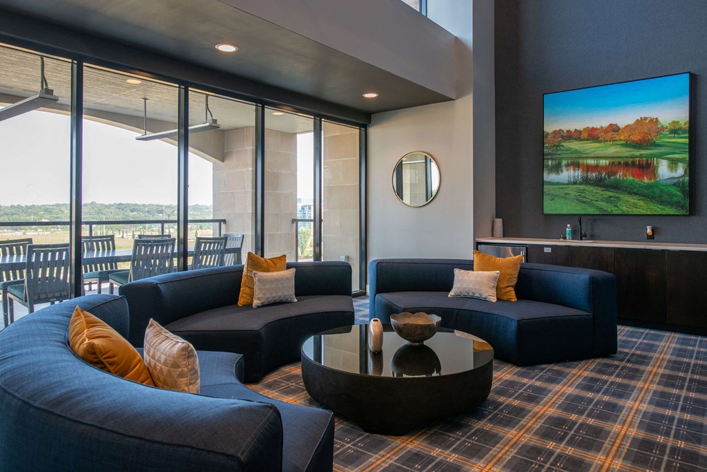 half circle couch around circular black table in a room with big windows and a counter at The Apex at CityPlace, Overland Park, KS