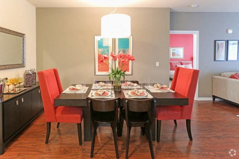 A dining room with a table set for a meal.
