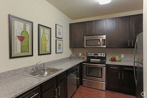 A kitchen with a stove top oven and a refrigerator.