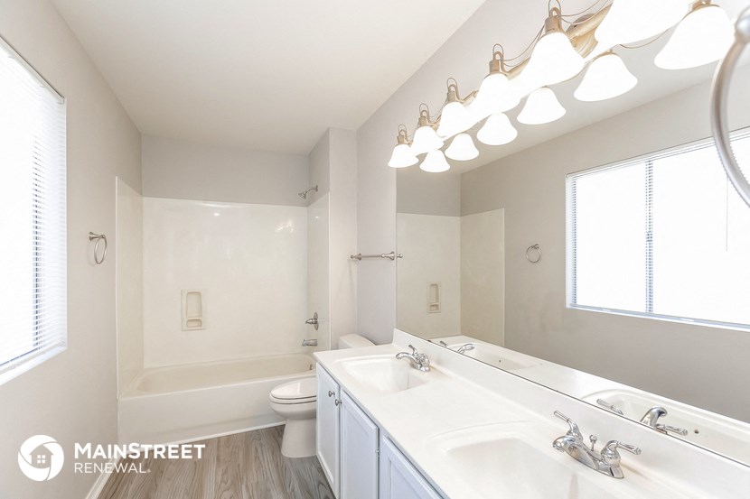 a bathroom with two sinks and a shower and a toilet