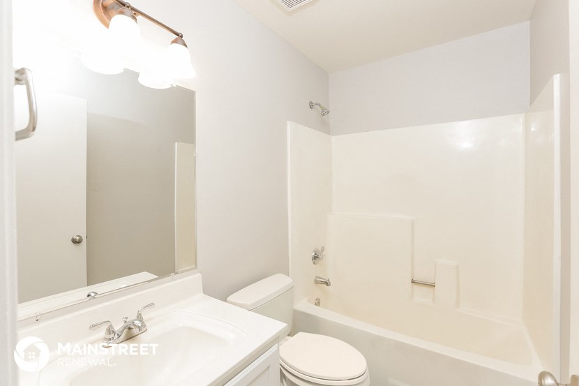 a white bathroom with a white toilet and a sink
