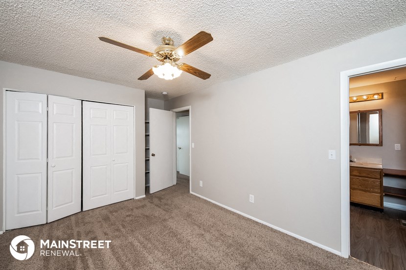 a living room with carpet and a ceiling fan