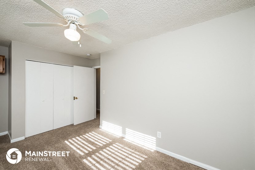 a bedroom with a ceiling fan and a closet