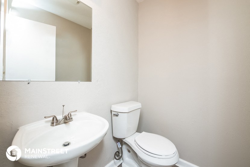a bathroom with a toilet and a sink and a mirror