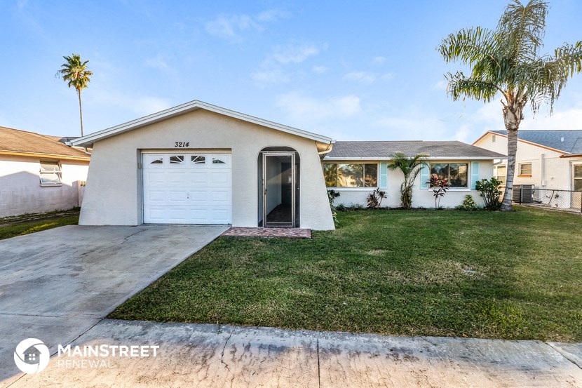 a white house with a white garage door and a lawn