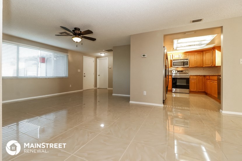 a kitchen and living room with tile flooring and a ceiling fan