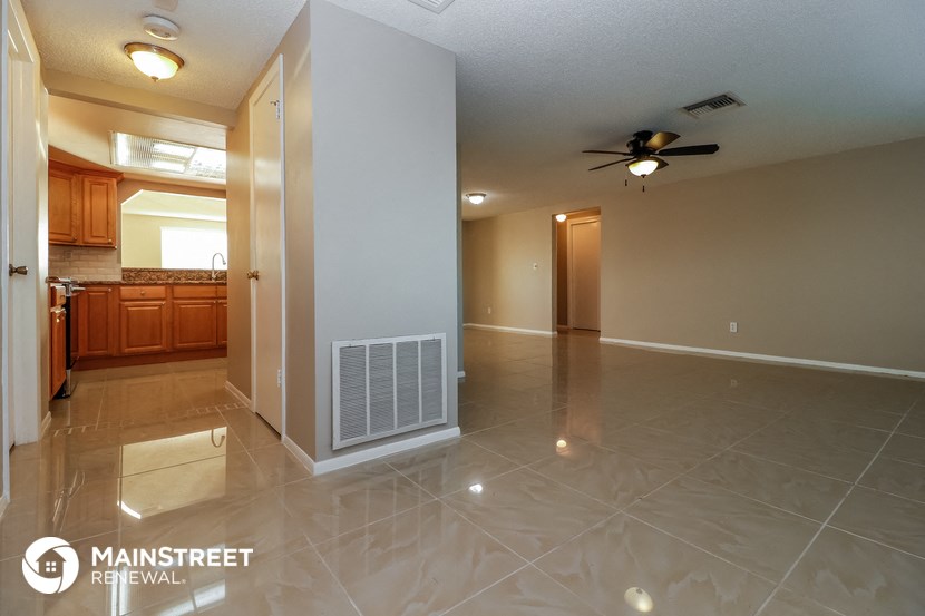 a kitchen and living room with tile flooring and a ceiling fan