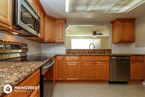 a kitchen with granite counter tops and wooden cabinets