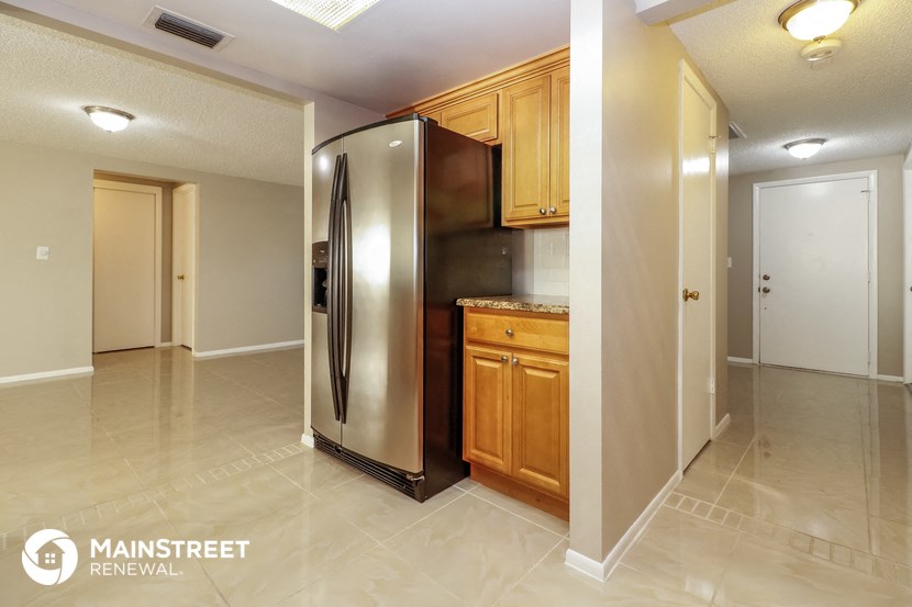 a kitchen with a stainless steel refrigerator and wooden cabinets