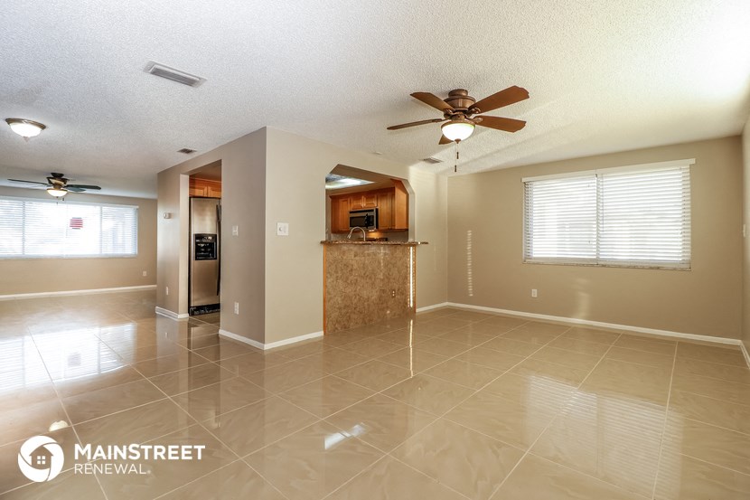 a kitchen and living room with tile flooring and a ceiling fan