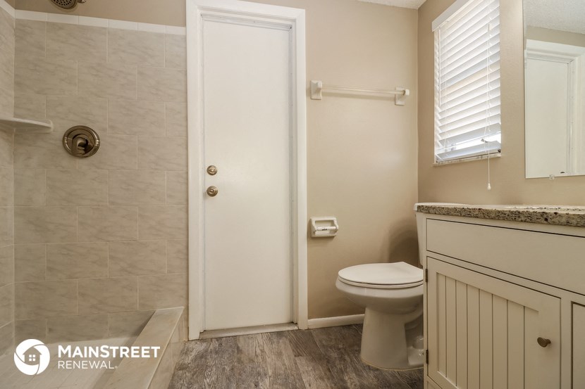 a bathroom with a toilet and a shower and a sink