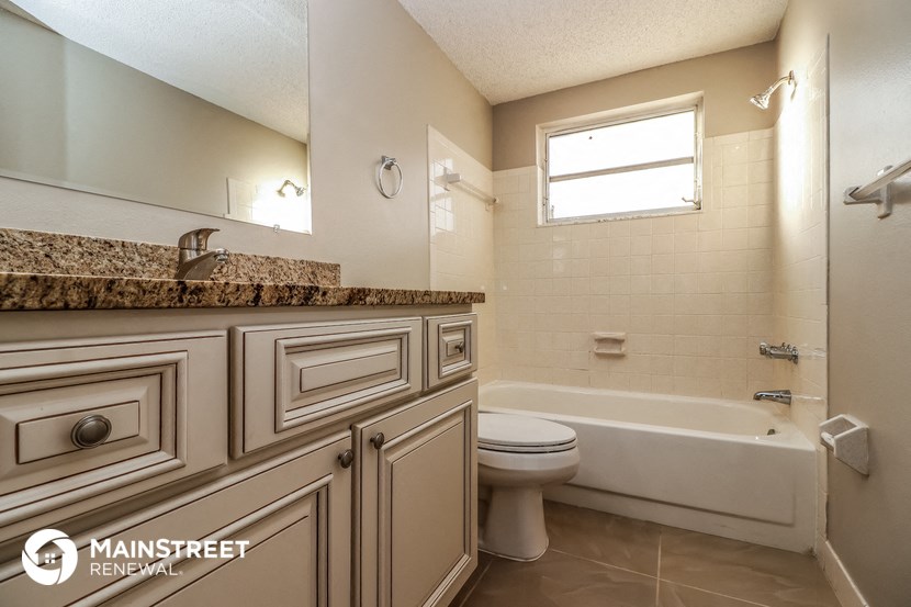 a bathroom with a toilet and a tub and a sink