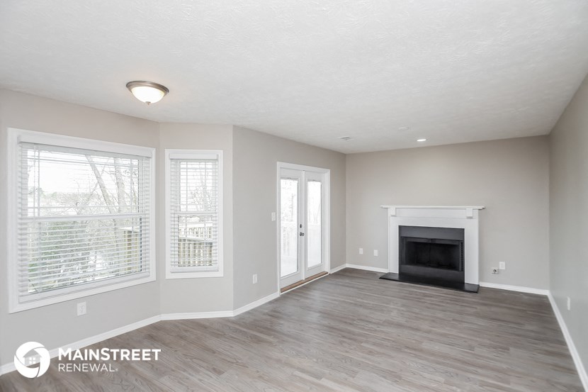 the living room of an apartment with a fireplace