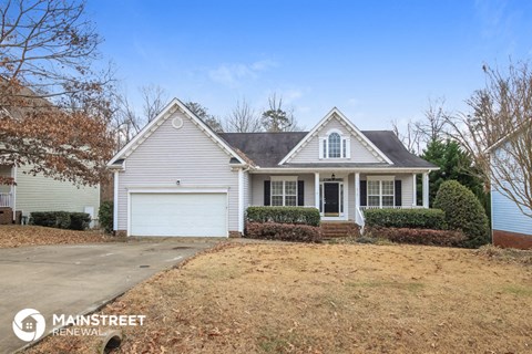 a small white house with a driveway and a lawn