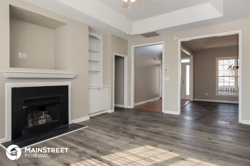 the living room has a fireplace and hardwood floors